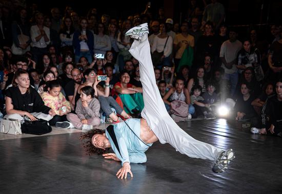 Un jeune danseur performe sur la scène du TnBA au milieu d'une foule captivée