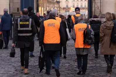 Photos de bénévoles de la Nuit de la Solidarité de dos dans la cour de l'Hôtel de ville