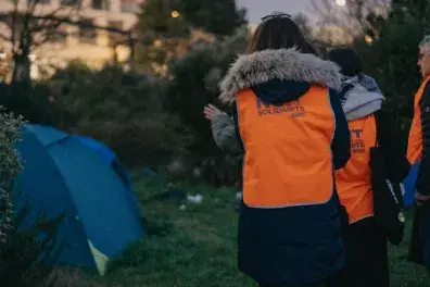 Photo de trois bénévoles de la nuit de la Solidarité devant une tente