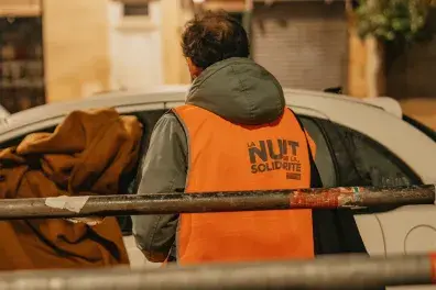 Photo d'un bénévole de la Nuit de la solidarité face à la voiture d'une personne sans-abri