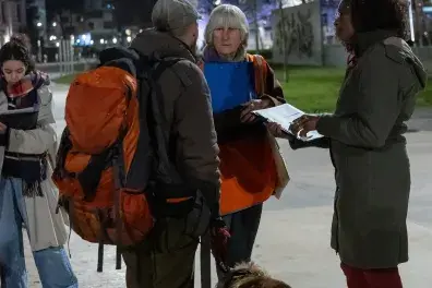 Photo de bénévoles remplissant un questionnaire face à une personne sans-abri avec son chien