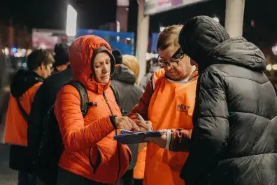 Photo de bénévoles remplissant un questionnaire à coté d'une personne sans-abri