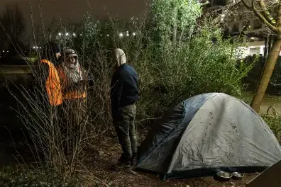 Photo de 2 bénévoles de la Nuit de la solidarité et d'un personne sans-abri devant une tente