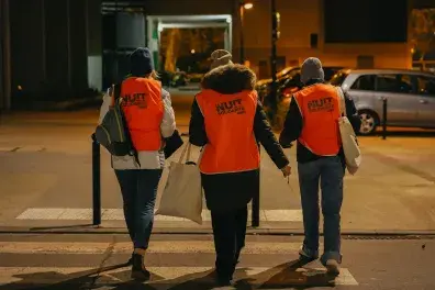 Photo de nuit de bénévoles de la Nuit de la solidarité marchant dans la rue