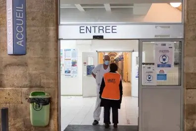Photo d'un bénévole et d'un infirmier à l'entrée d'un hôpital