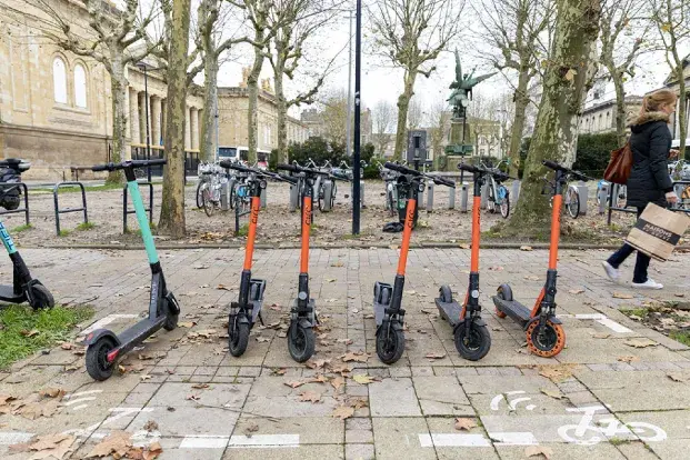 Des trottinettes garées sur un emplacement aménagées pour elles.