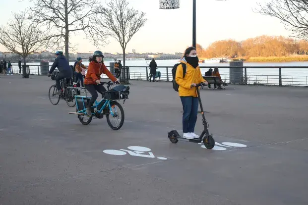 Une trottinette et un vélo sur une piste dediée.