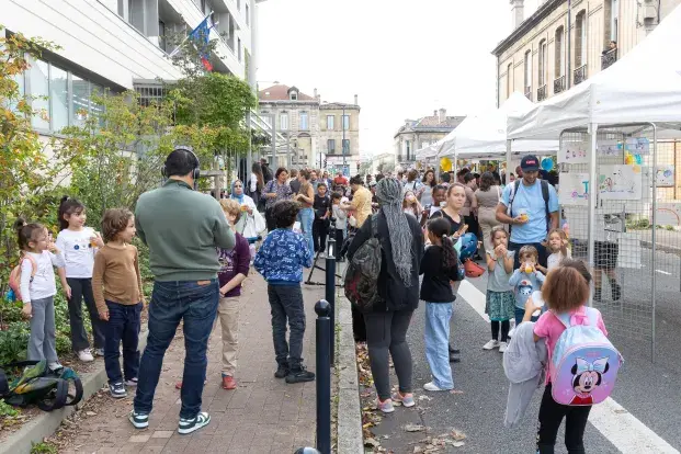 Photo des familles qui marchent dans une rue de Bordeaux pour accéder à une école.