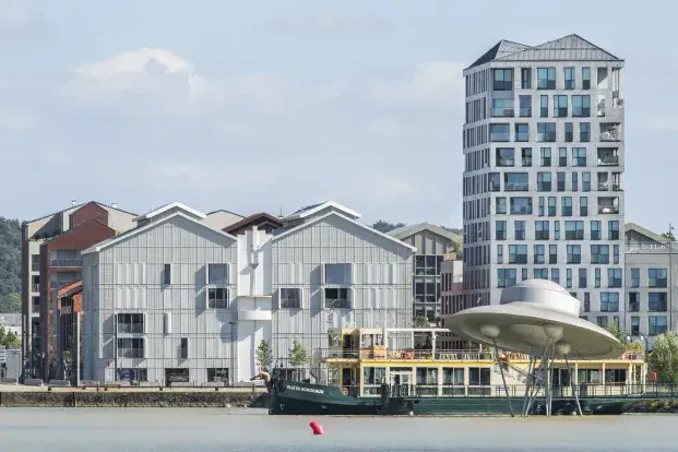 Photo de la soucoupe des bassins à flot avec une péniche et des immeubles en arrière plan.