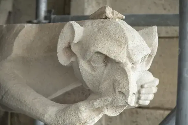 Photo d'un tailleur de pierre au travail sur le chantier de la flèche Saint-Michel.