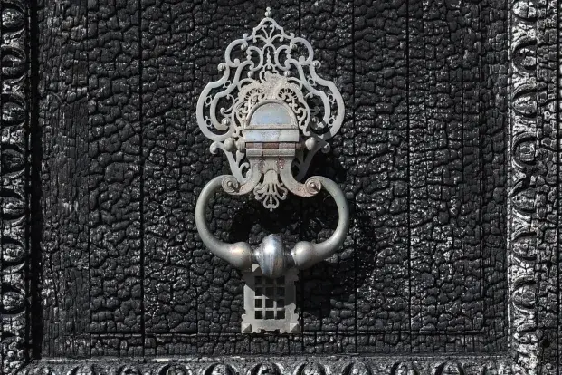 Photo de la poignée de porte de l'hôtel de ville, entourée par le bois calciné.