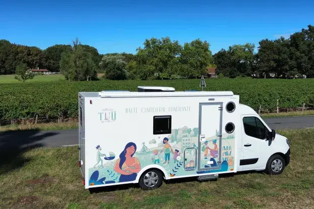 Le véhicule utilitaire de la halte-garderie itinérante stationné au bord d'une route de campagne