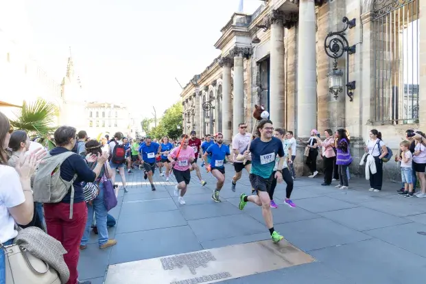 Photo des coureurs et de la foule de la 3e Nuit des relais sur la place Pey Berland en juin 2024