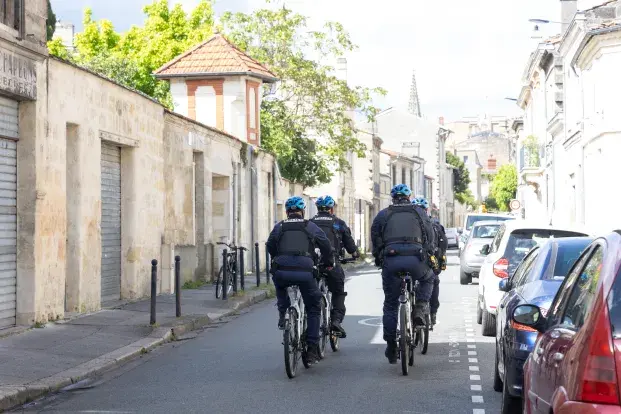Photo de plusieurs policiers municipaux à vélo dans une rue de Bordeaux