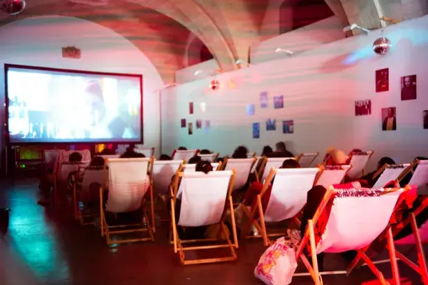 Spectateurs assis dans des transats, regardant une séance de cinéma.