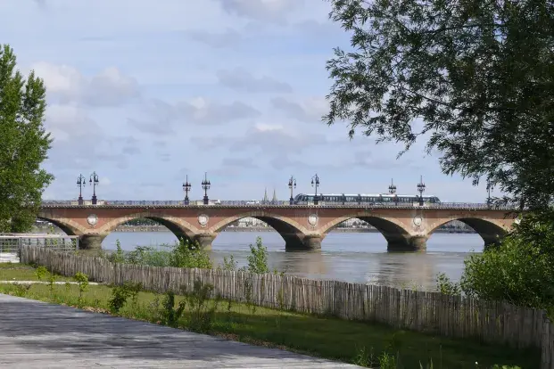 Photo du pont de pierre à Bordeaux, sur fond de ciel bleu.
