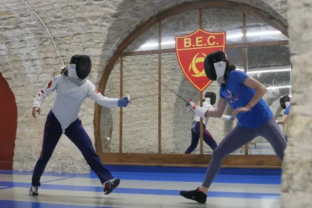 photo de deux escrimeurs s'affrontant sur une piste d'escrime.