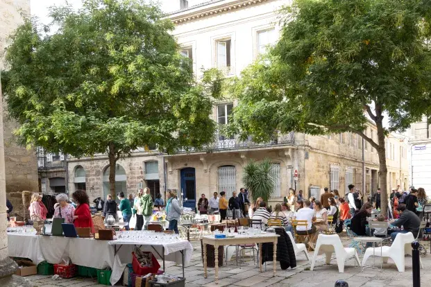 Photo de stands de brocante et de passants dans une rue des Chartrons, à Bordeaux