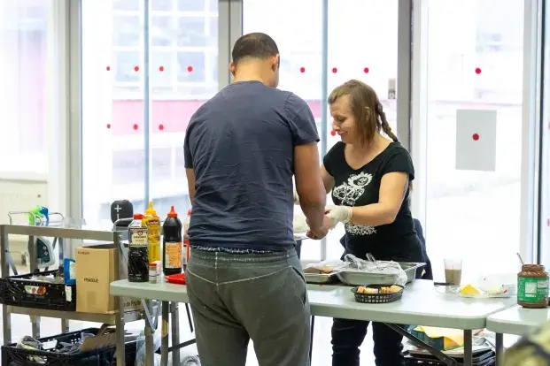 Deux personnes sont devant une table avec des ingrédients pour le petit déjeuner