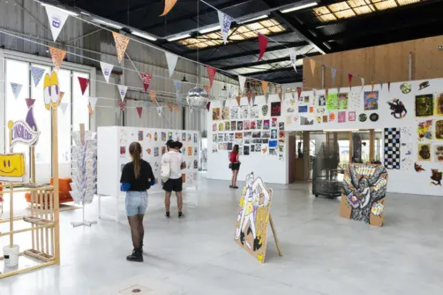 photo d'une exposition graphique à la fabrique pola, avec des visiteurs, de dos