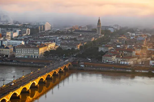Photo en hauteur de la vue sur le pont de pierre et la place Stalingrad sur la rive droite de Bordeaux sous la brume matinale