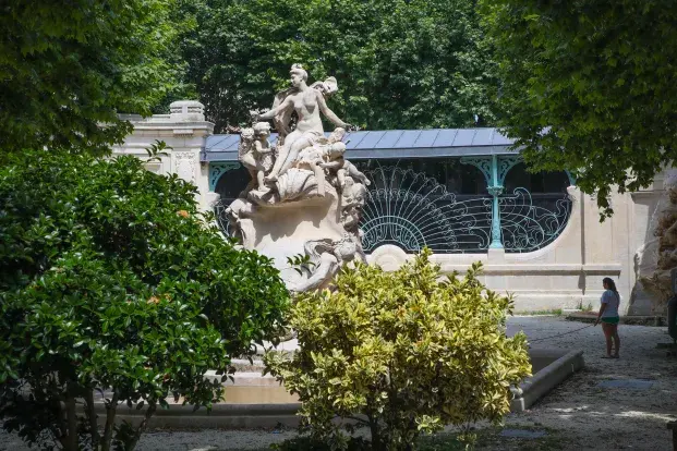 La place Amédée Larrieu, avec des arbres, une fontaine et en arrière plan la salle art-déco.