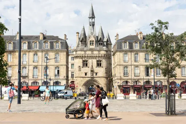 Photo de la porte Cailhau et d'une famille avec poussette