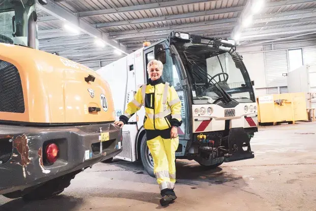 Une agente de la propreté de Bordeaux Métropole devant son camion.