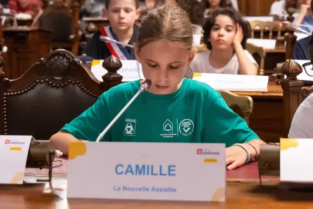 Photo de Camille, membre du Conseil Municipal des Enfants qui présente le projet de son groupe "La Nouvelle Assiette"
