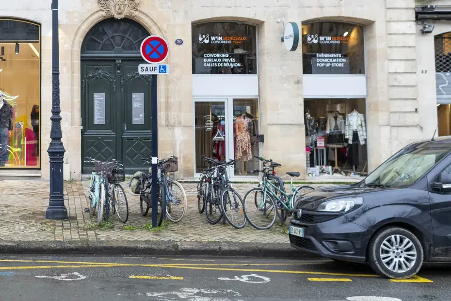 Une rue de bordeaux avec des vélos stationnés sur le bord.