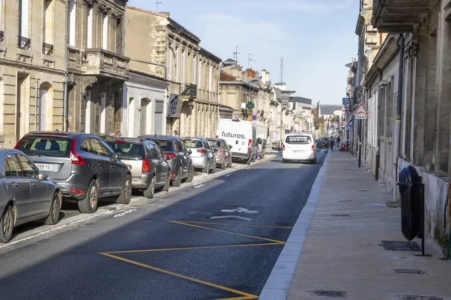 Une rue de bordeaux avec des voitures stationnées sur le bord.