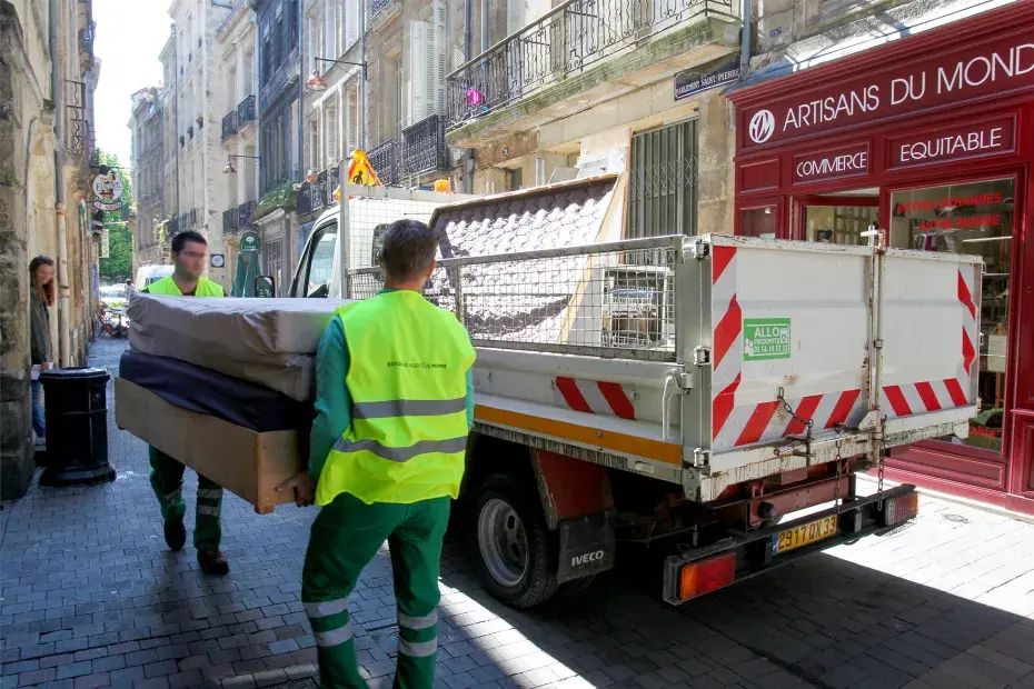 Deux agents chargeant des encombrants dans un camion