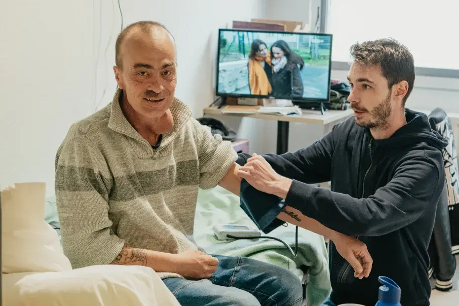 Un homme reçoit des soins, il se fait prendre la tension.