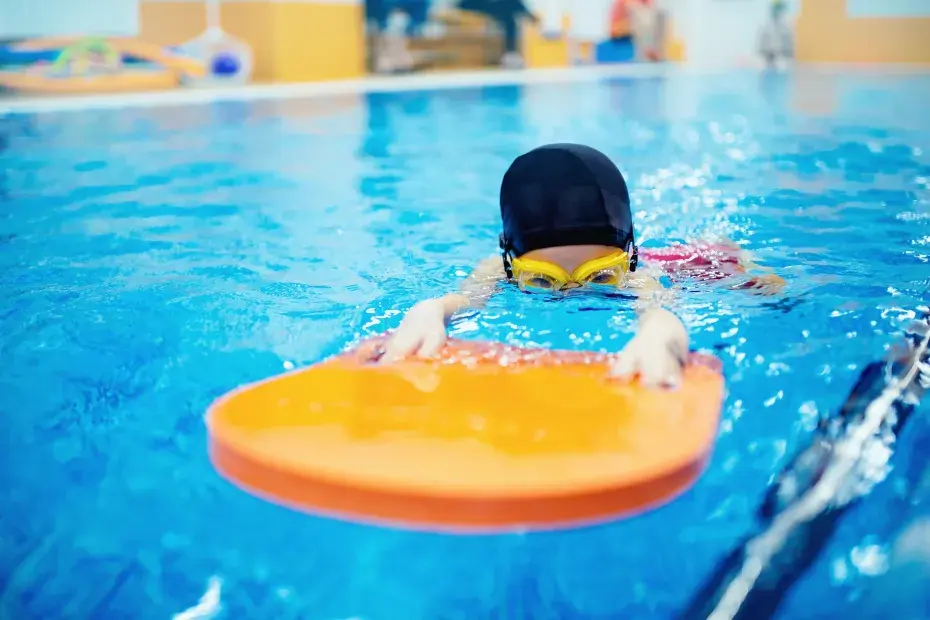 Photo d'un bébé nageur dans une piscine une planche.