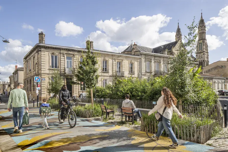 Photo de la Place Wangari Muta Maathai à Bordeaux Sud, avec des passants et en arrière plan la forêt urbaine