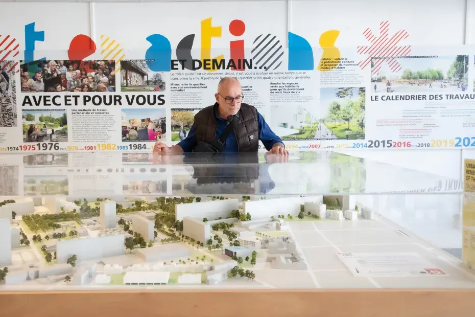 Un homme regarde une maquette du quartier Grand Parc.