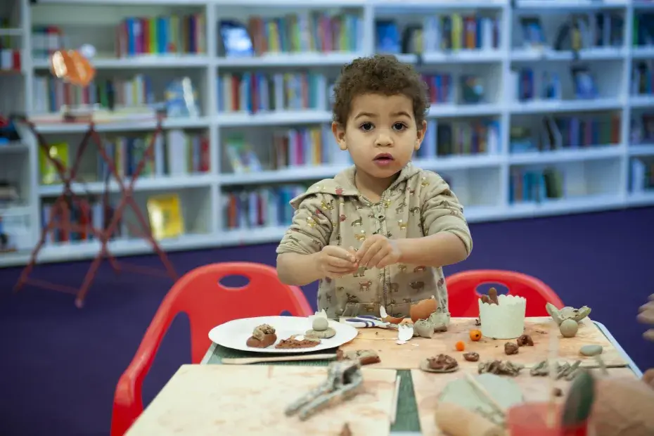 Un petit garçon participe à un atelier modelage.