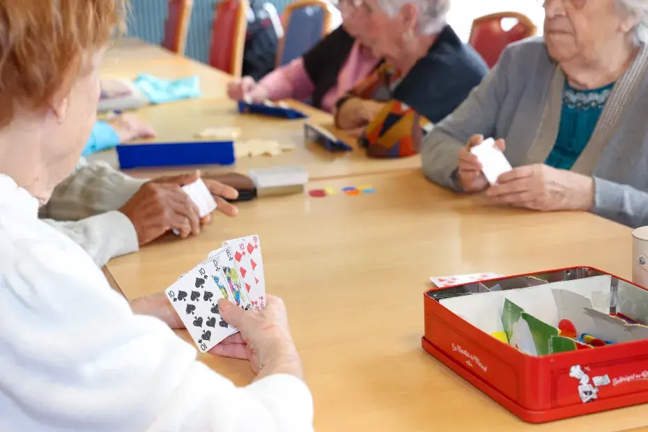 Des personnes âgées jouent aux cartes.