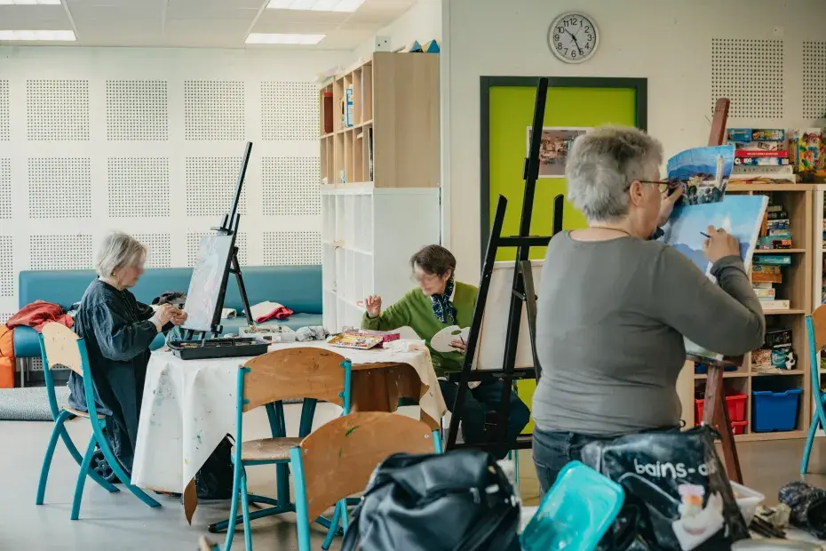 Trois personnes peignent des tableaux