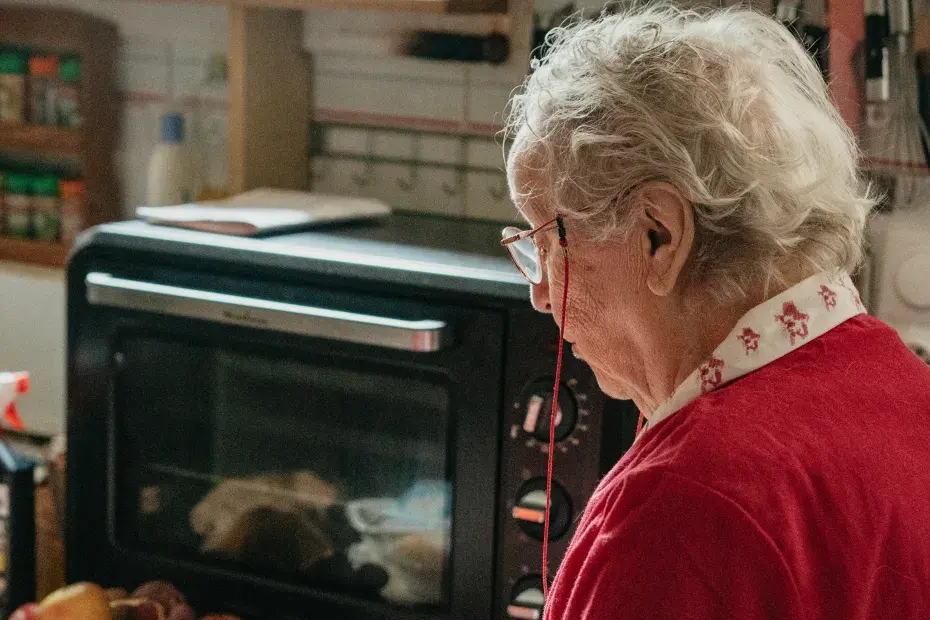 Une personne âgée se trouve dans sa cuisine.
