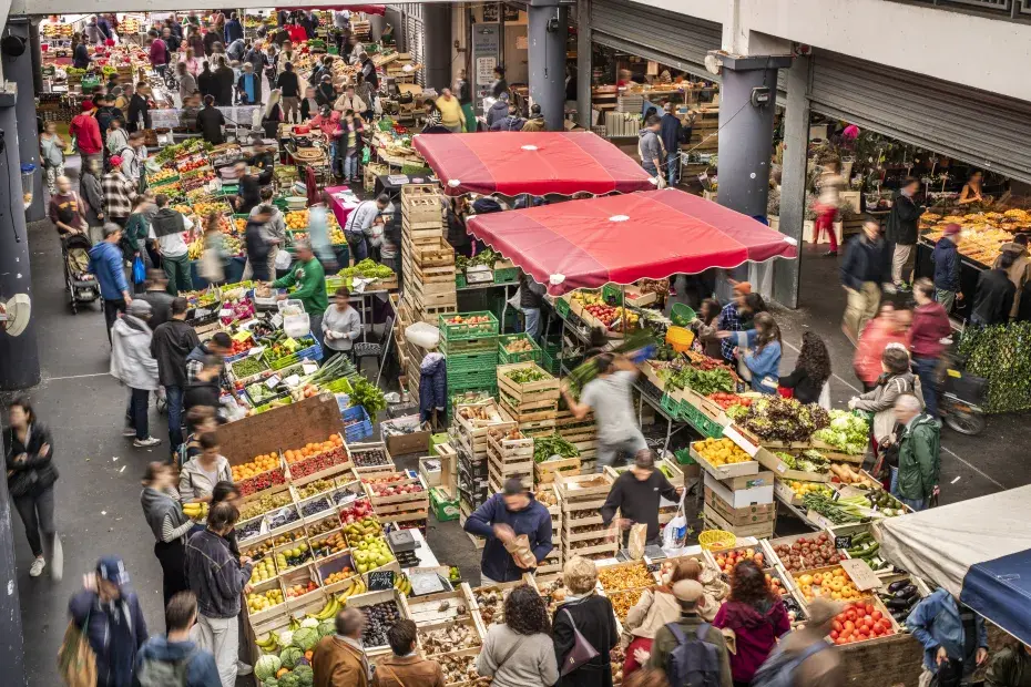 Photo vue de haut du marché couvert des Capucins, avec des étals de fruits et légumes et du public