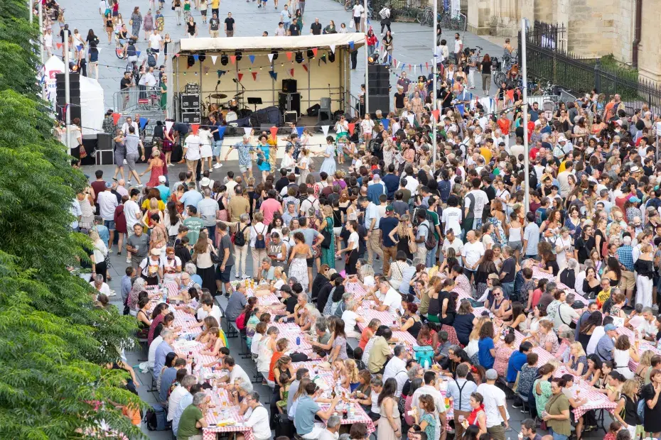Photo d'une foule debout et assise à des tables place Pey Berland