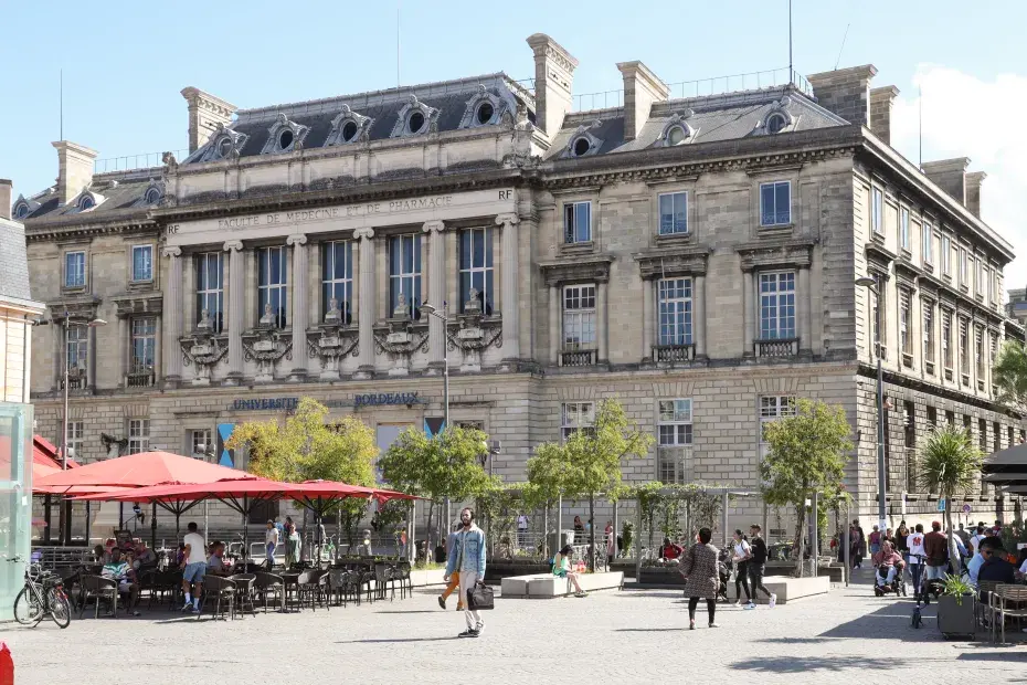 Vue extérieure du campus Victoire de l'université de Bordeaux, avec les terrasses de cafés sur la place de la Victoire