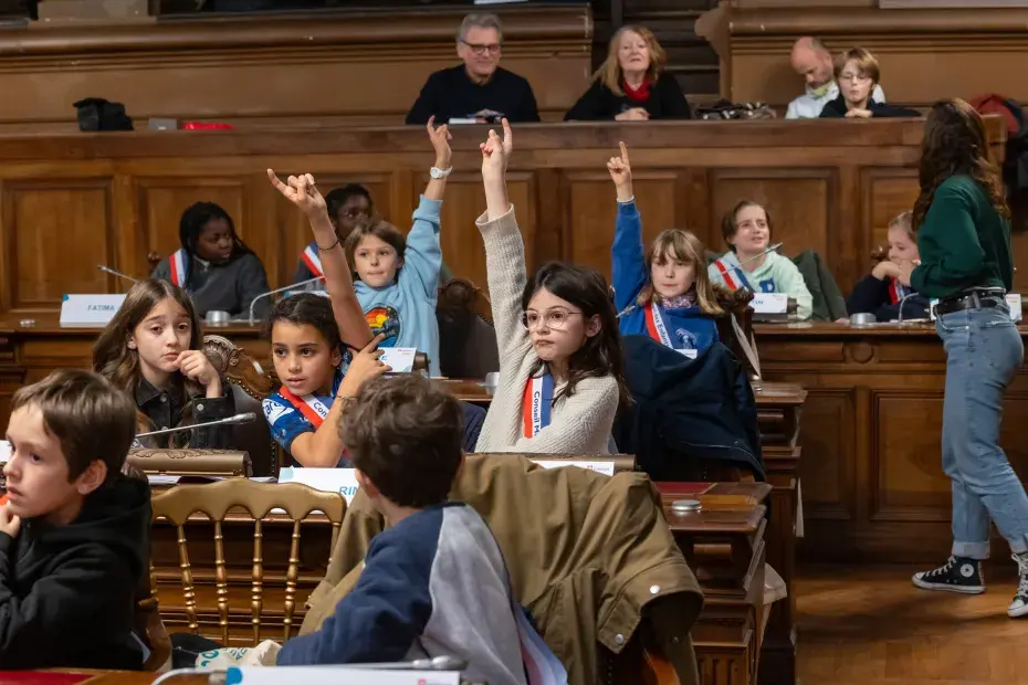 photo d'enfants votant à main levé dans la salle du conseil municipal de bordeaux