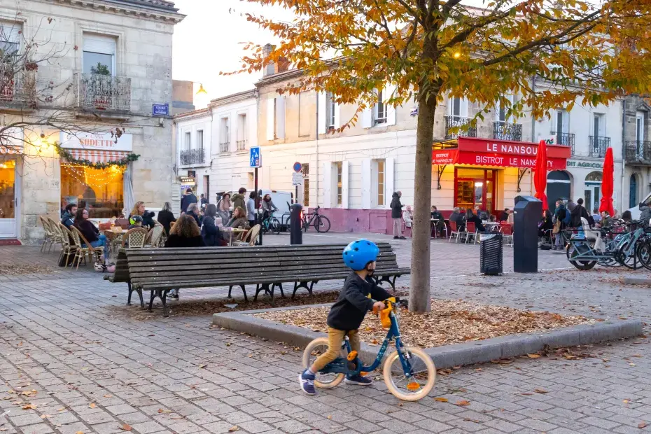 photo de la place Nansouty à Bordeaux, avec un enfant de dos en draisienne.