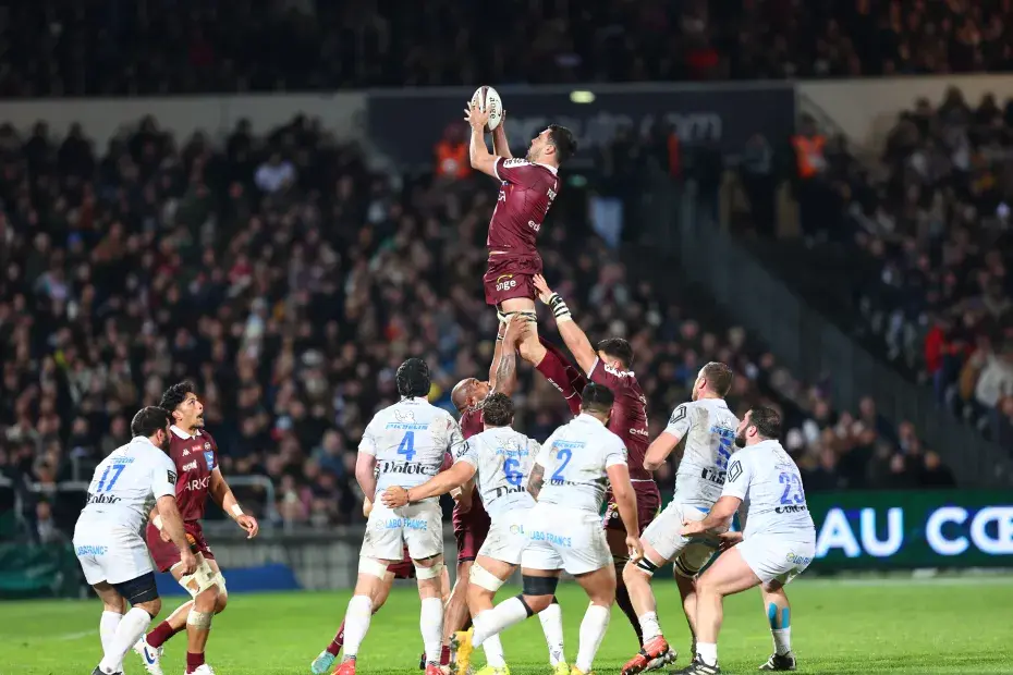 photo de rugbymen en action, dans un stade avec du public