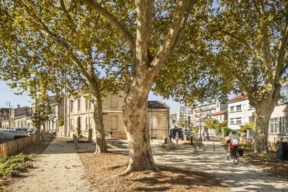 photo d'une place à caudéran, avec des passants et un cycliste.