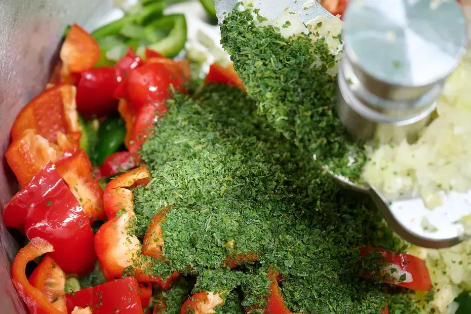 Des poivrons rouges et verts, du persils et de l'oignon découpés