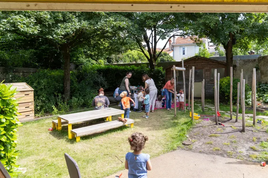 Des enfants et des femmes dans un jardin verdoyant
