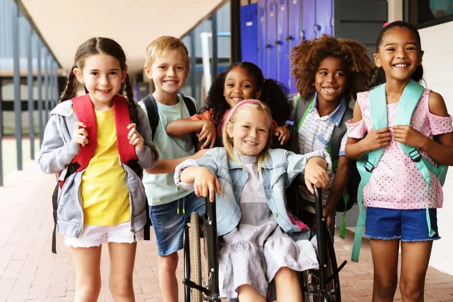 Photo d'un groupe d'élève dans une école autour d'un enfant en situation de handicap